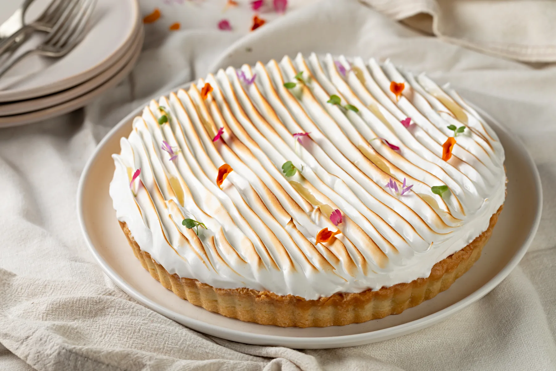 Torta de limão coberta de merengue queimado e flores comestíveis